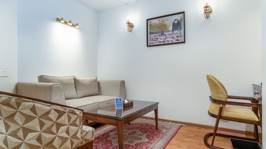 A living area with chairs, a coffee table and painting hanging from the wall - Sarovar Premiere, Srinagar